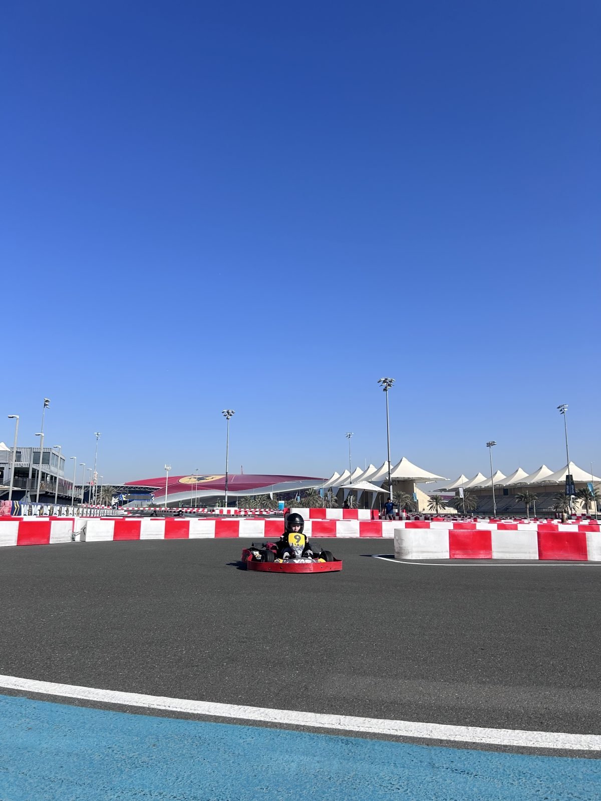 Otrok v gokartu na dirkališču Yas Marina Circuit v Abu Dhabi, med družinskim potovanjem.