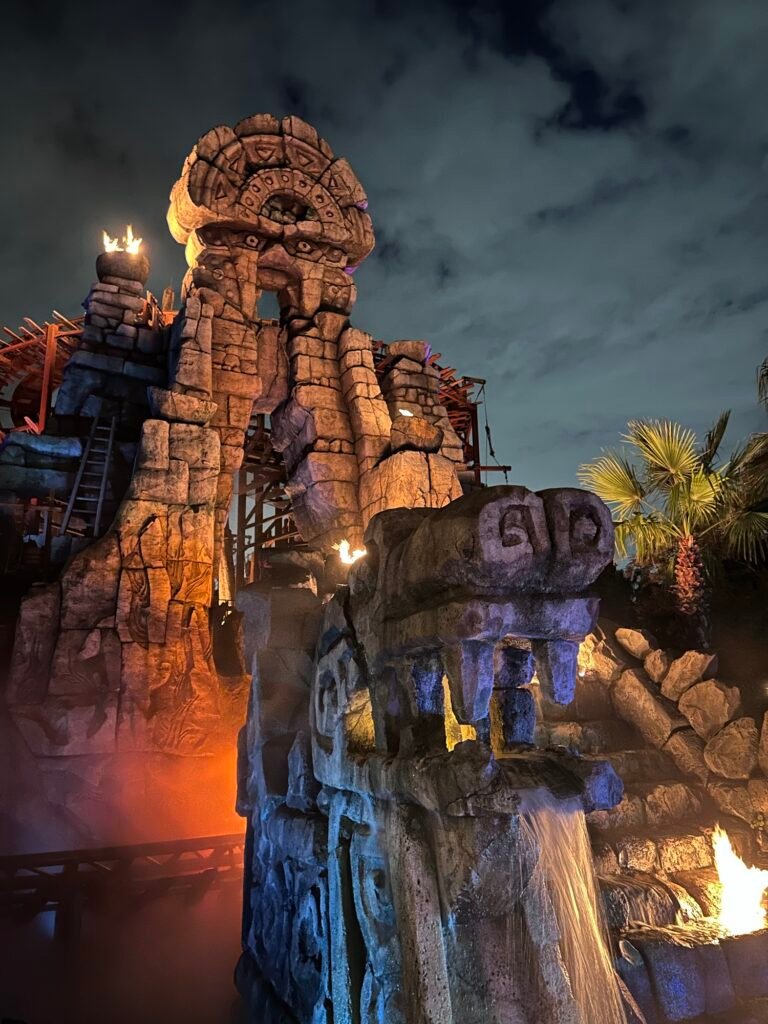 Illuminated ancient temple ruins, waterfall and fire effects at Raging Spirits in Tokyo DisneySea vs Universal Studios Japan
