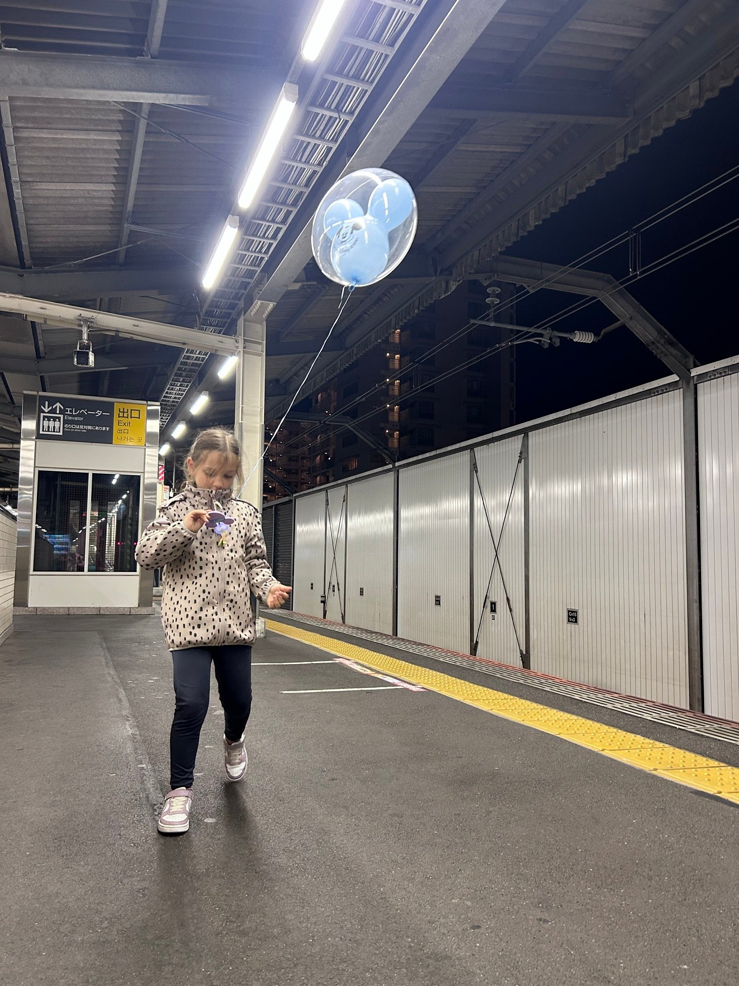 Child waiting for a Tokyo train after visiting DisneySea