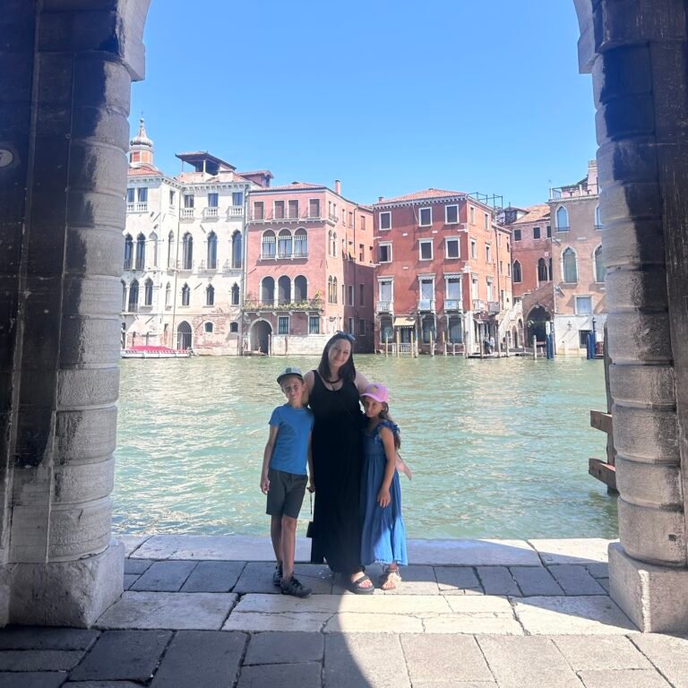Family exploring Venice with kids beside the Grand Canal