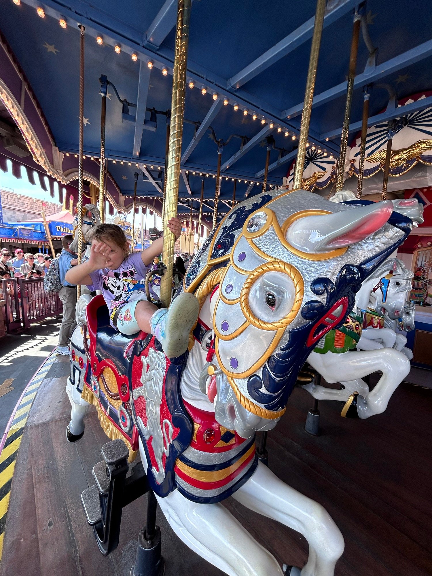 Young girl riding a decorated carousel horse at Magic Kingdom